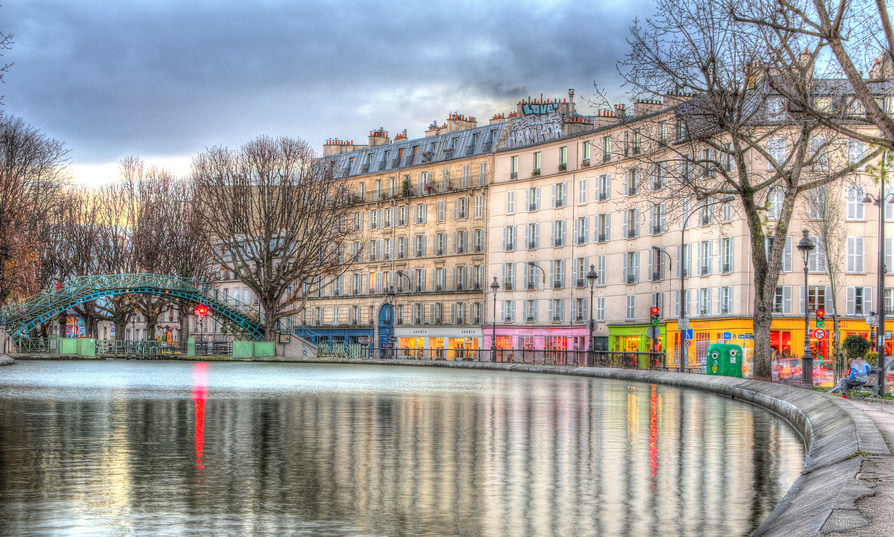 Le Canal Saint-Martin, situé dans le 10ᵉ arrondissement de Paris. Il est bordé d'immeubles haussmaniens et des cafés et boutiques colorés
