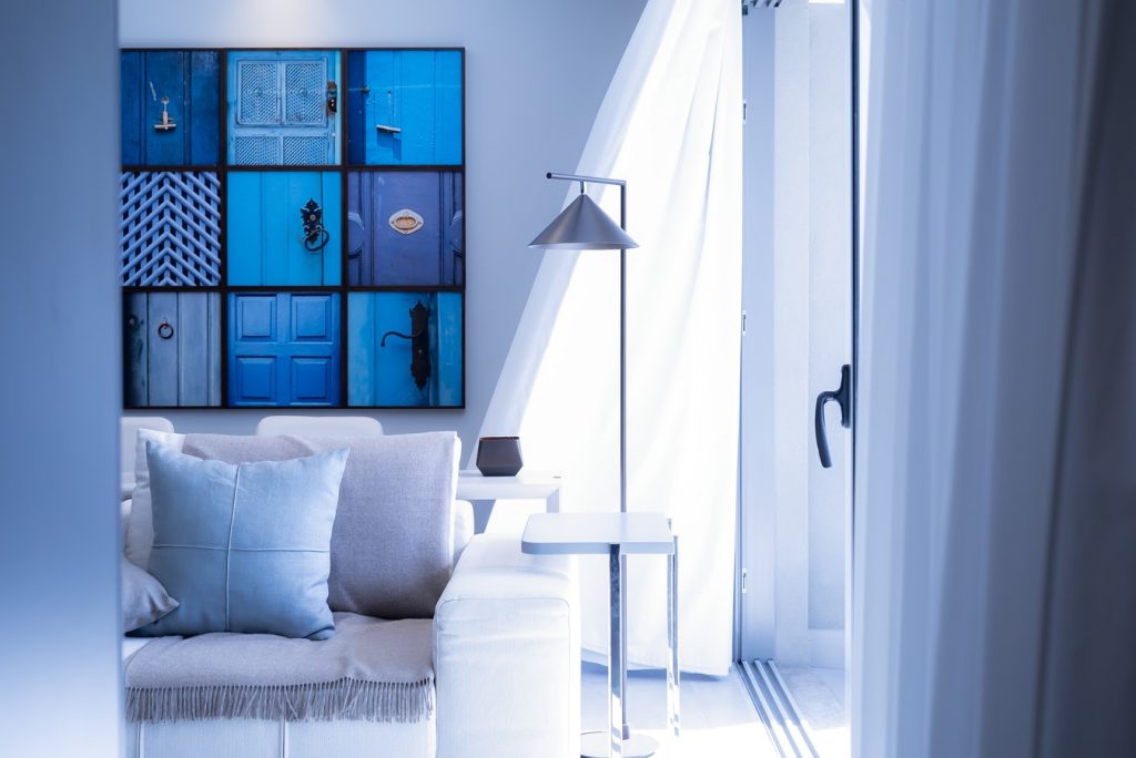 Salon lumineux moderne avec décoration bleue et tableau artistique, un intérieur d’appartement à louer