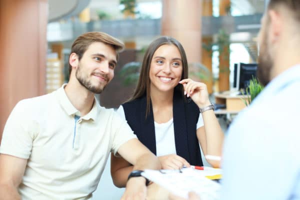 Un couple heureux avec leur courtier pour faire un investissement locatif