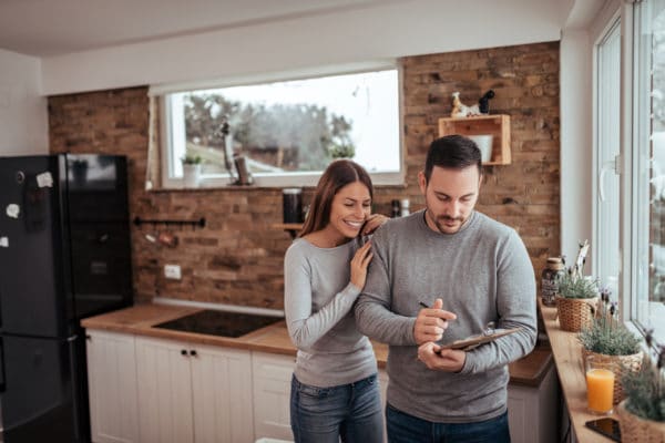 Un couple heureux qui est en train de signer leur premier investissement locatif