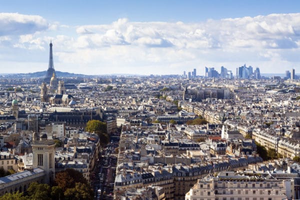 Vue panoramique sur Paris, avec la Tour Eiffel et le quartier d’affaires de La Défense à l’horizon.