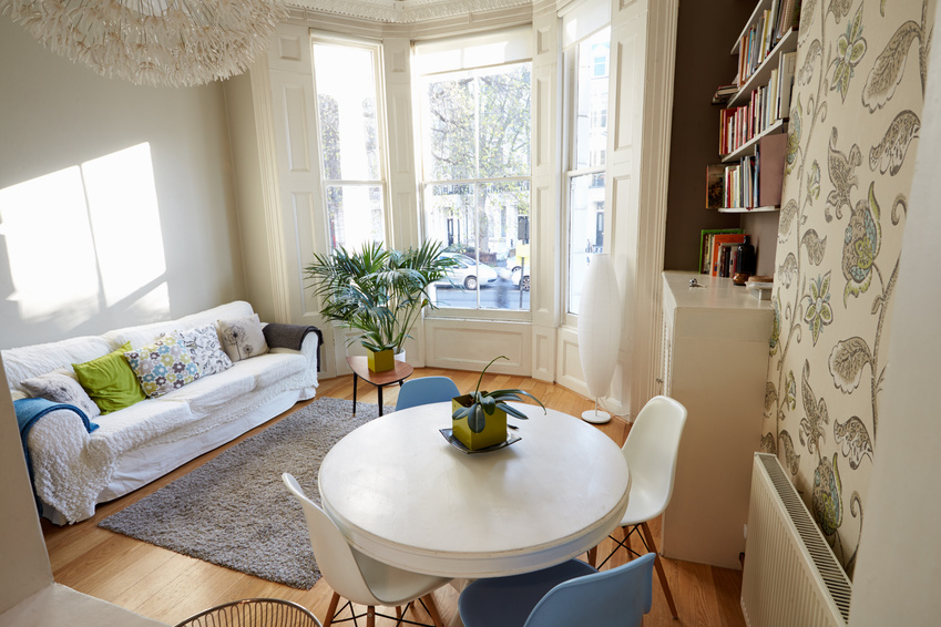Bright and modern living room with a large bay window, decorated in a cozy and contemporary style.