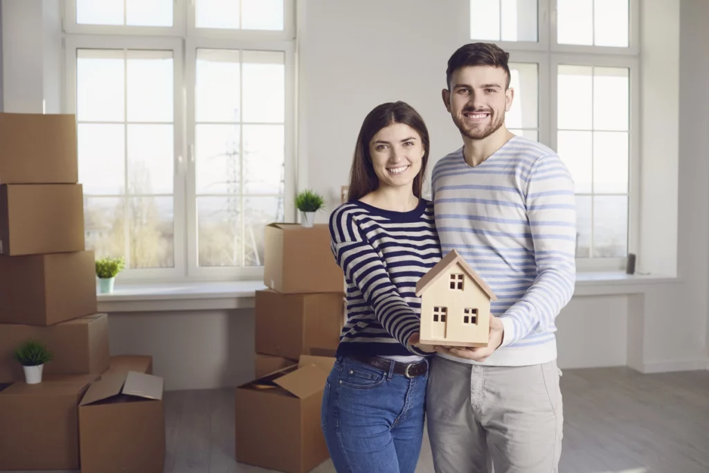 Un homme et une femme heureuse de déléguer la gestion de leur premier investissement locatif à une agence de gestion