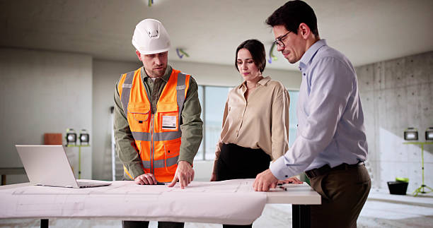 Un promoteur immobilier analysant les coûts et les charges de travaux pour aider son client qui veut investir à Marseille