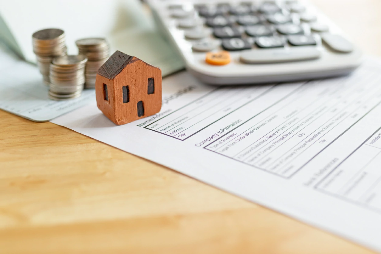 Maison miniature en bois, pièces de monnaie et documents d'impôt