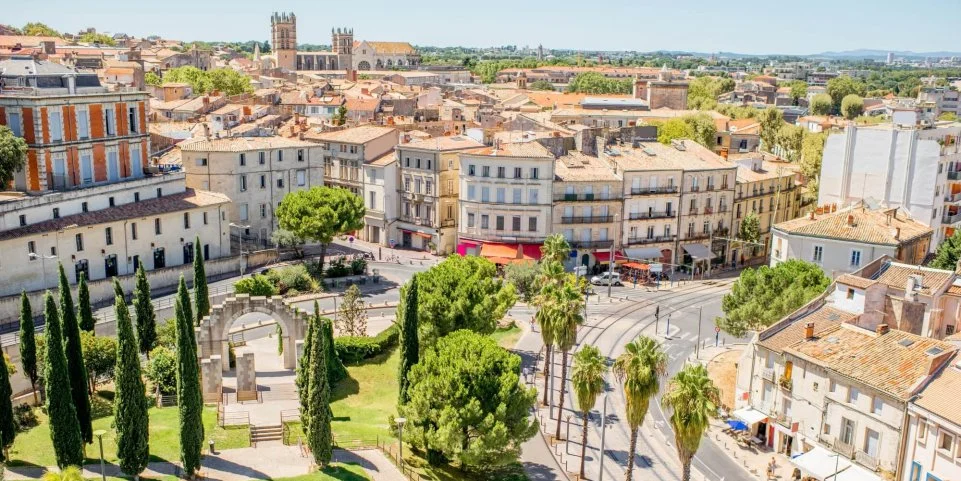 Vue sur le centre historique de Montpellier avec ses résidences anciennes, commerces et cafés, illustrant un quartier prisé pour l’investissement locatif et la vie urbaine des habitants