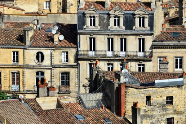 Toits et façades typiques du centre historique de Bordeaux, avec leurs pierres blondes et tuiles traditionnelles.