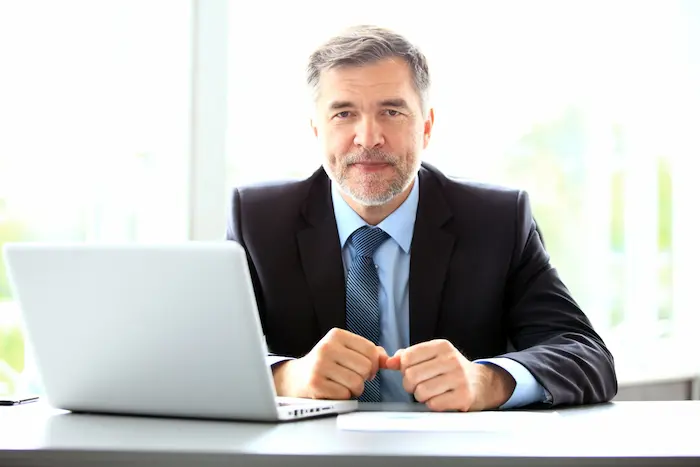 Un conseiller immobilier regardant son laptop concernant le justificatif de non-résidence fiscale.